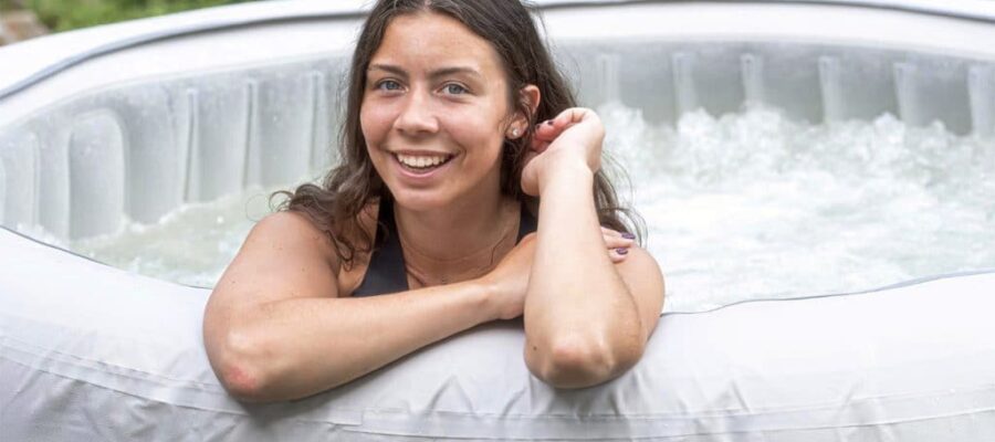 A young woman who smiles in a white inflatable spa